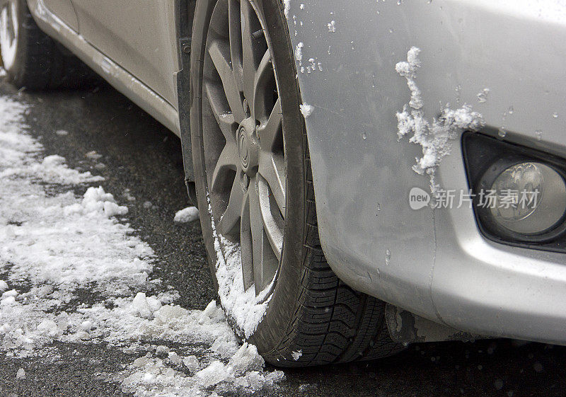 汽车轮胎在被雪覆盖的冬季道路上行驶