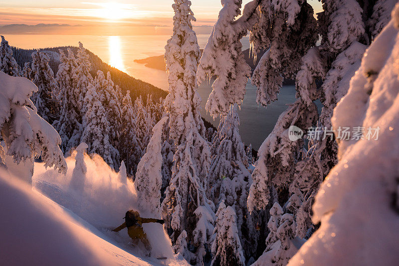 日出时，一名偏远地区的滑雪者从厚厚的粉雪中下山
