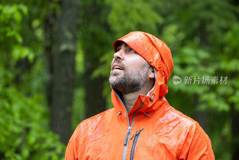 雨中漫步森林，穿着雨衣的快乐男人