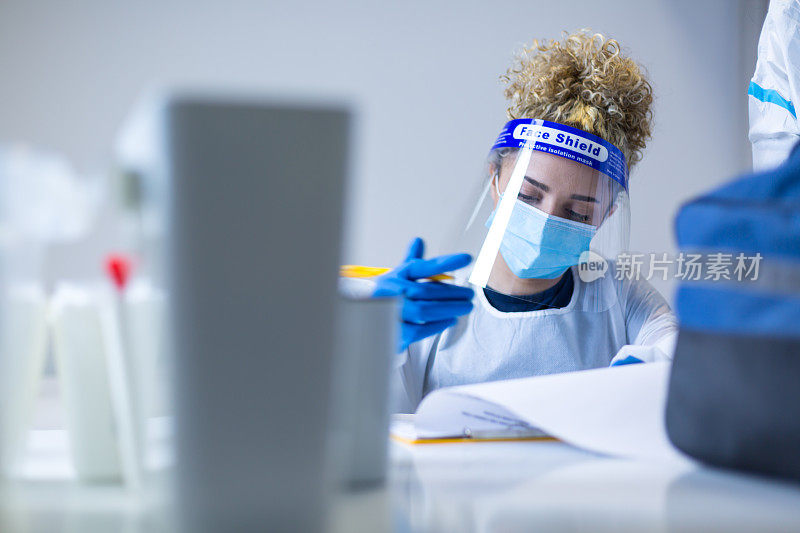 在冠状病毒covid-19免疫接种中心工作的戴着蓝色手套的医护人员