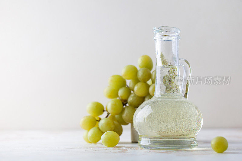 有机植物油从葡萄种子在玻璃瓶与绿色葡萄。