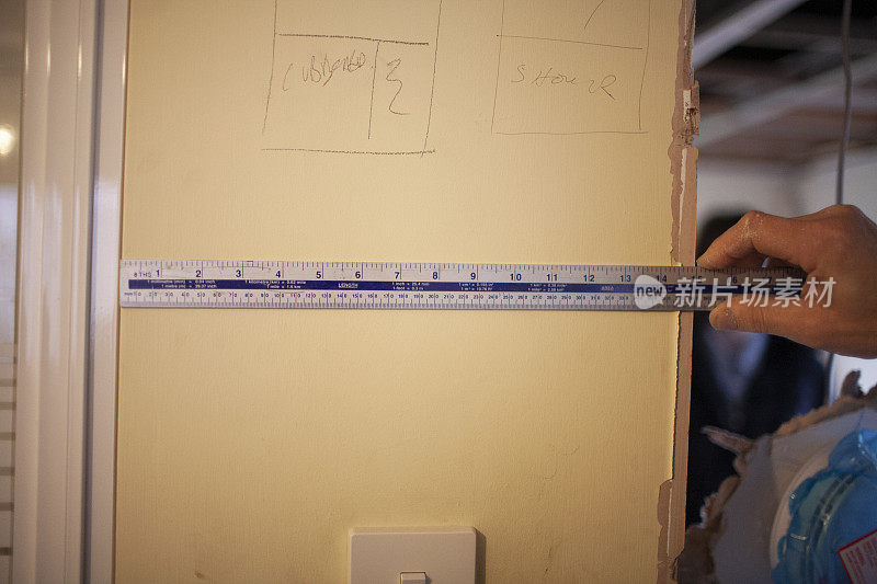 建筑工用金属尺测量石膏板墙