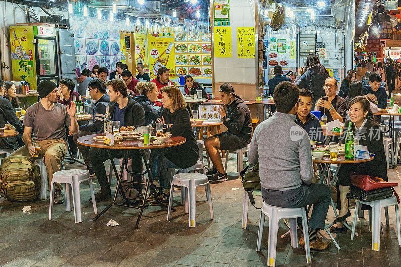 傍晚时分，人们坐在市中心街道的咖啡馆里。
