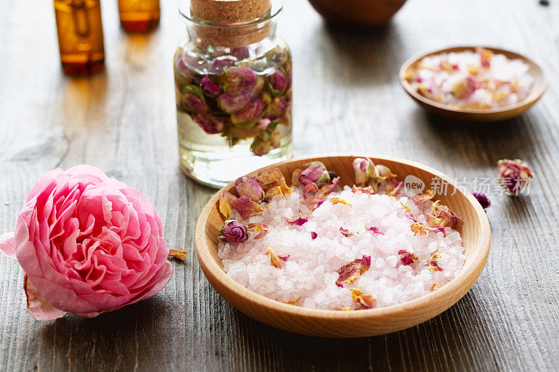 香薰:粉红色的玫瑰和带有玫瑰香味海盐的木碗