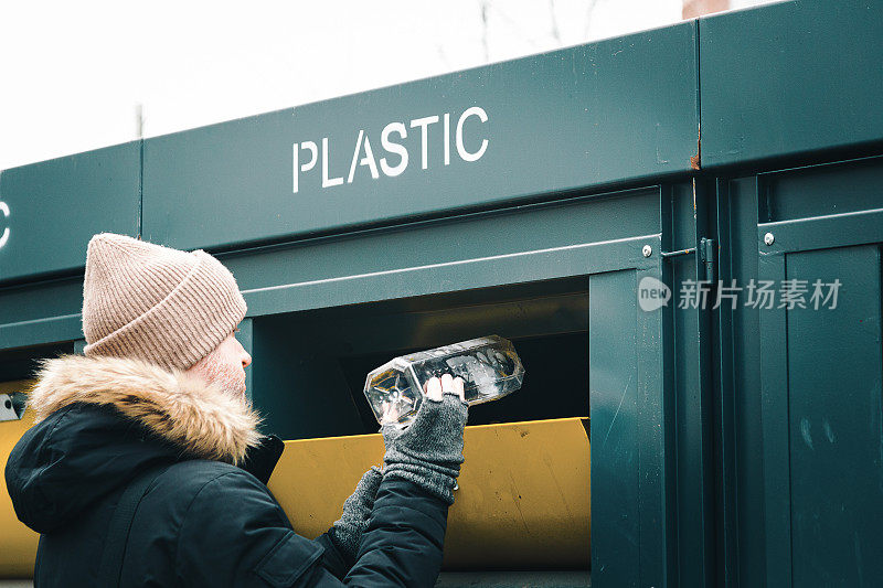 一个人在回收箱里回收塑料瓶