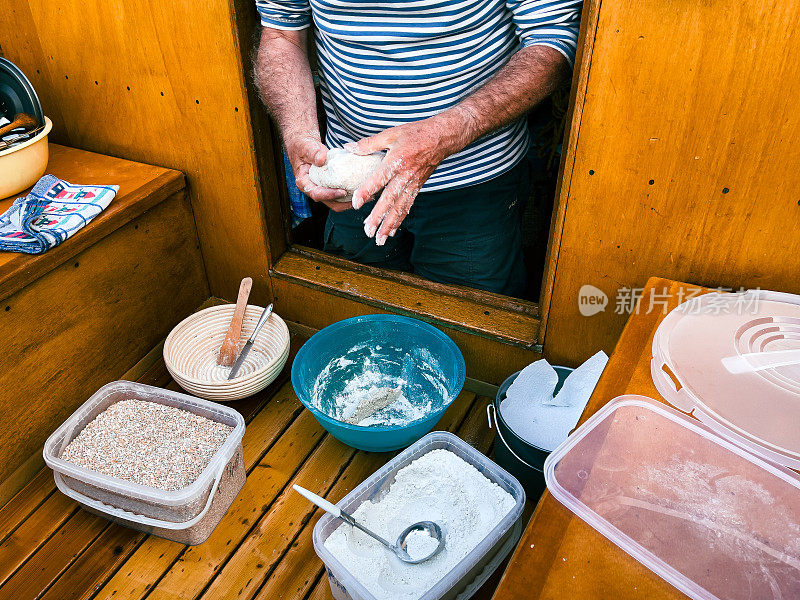 成熟的男人在他的帆船上准备面包，户外活动