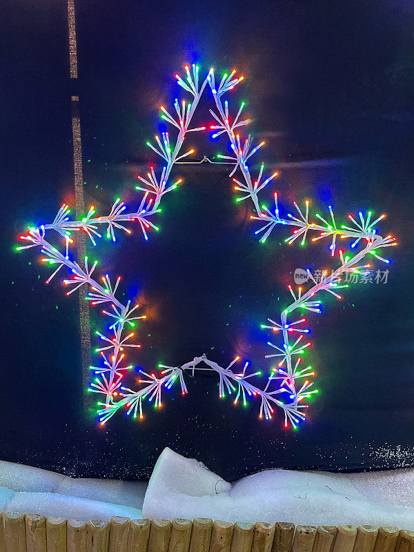 大的特写图像，点亮圣诞之星，五彩LED精灵灯，照亮圣诞装饰，黑色背景