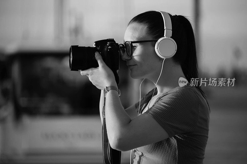 女游客用相机拍摄环境的黑白照片