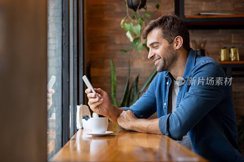 男人在咖啡馆喝咖啡的时候用手机