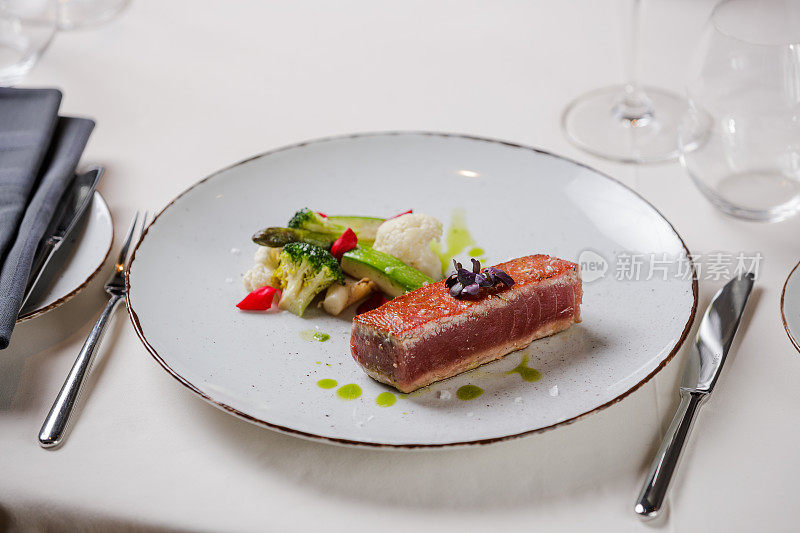 金枪鱼排配清蒸蔬菜在高级餐厅的盘子上装饰