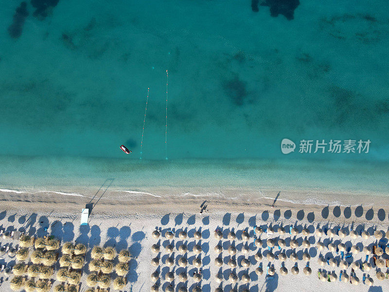 无人机拍摄的阿尔巴尼亚爱奥尼亚海岸的夏季海滩度假胜地的雨伞，罗施