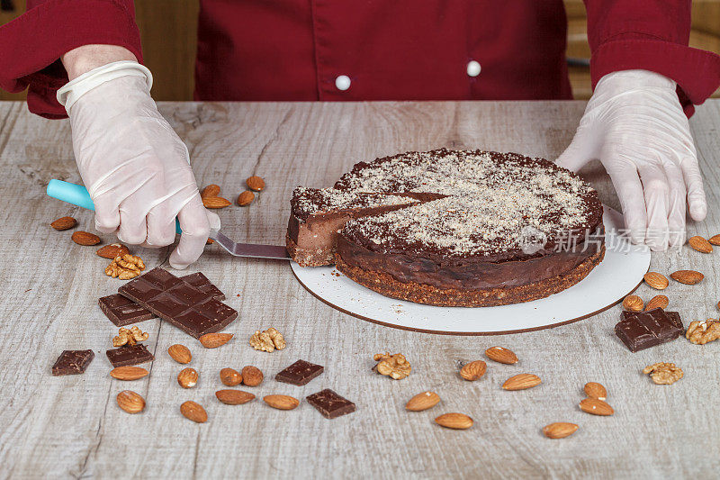 巧克力蛋糕与一块切块和刀片在灰色背景，特写