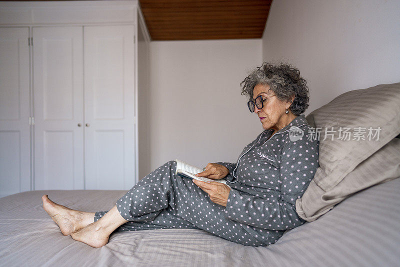 退休妇女在她的房间里看书休息
