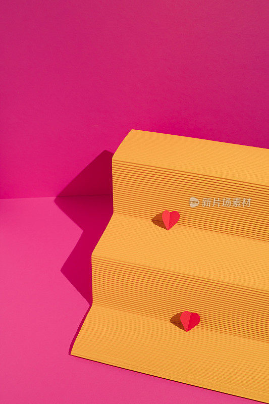 黄纸讲台，洋红色背景上有两颗红心。最小限度的爱或情人的概念。