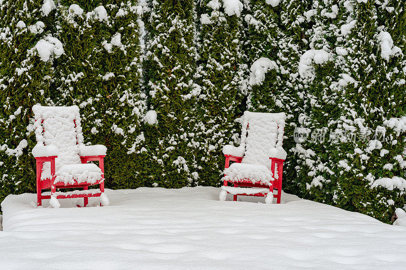 院子里的红色草坪椅上覆盖着积雪