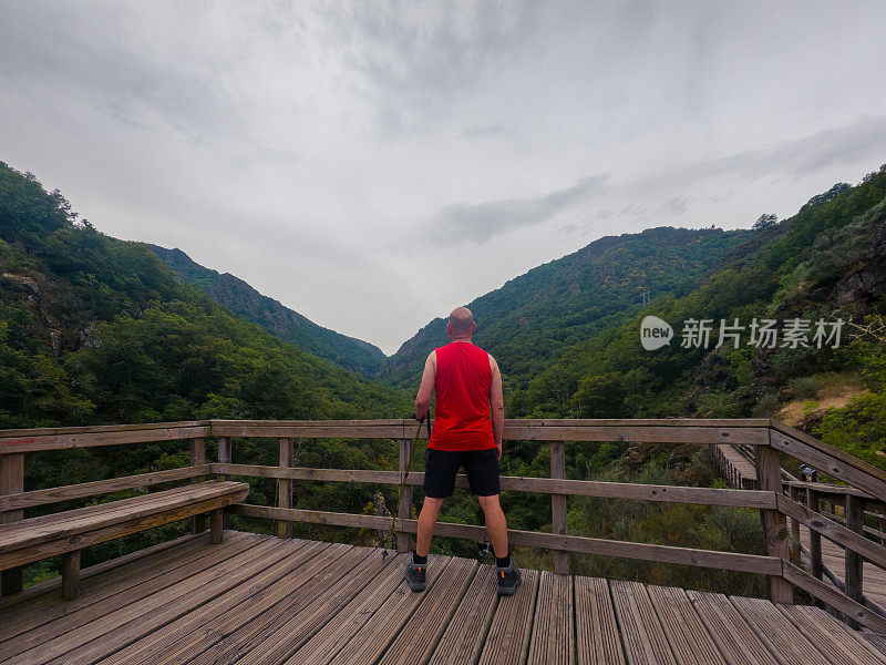 一个人在木制的瞭望台上观察风景。