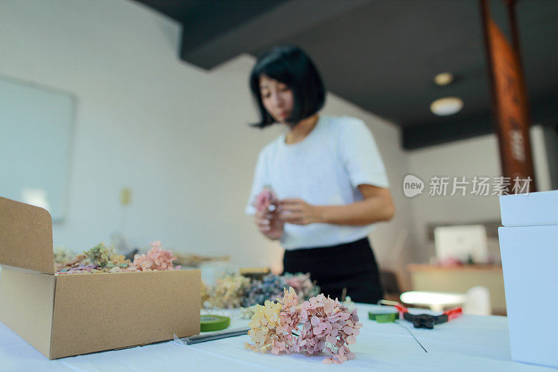 一位女花艺教师正在用绣球花制作花圈