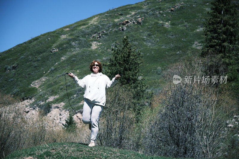 一个女人正在山谷里跳绳