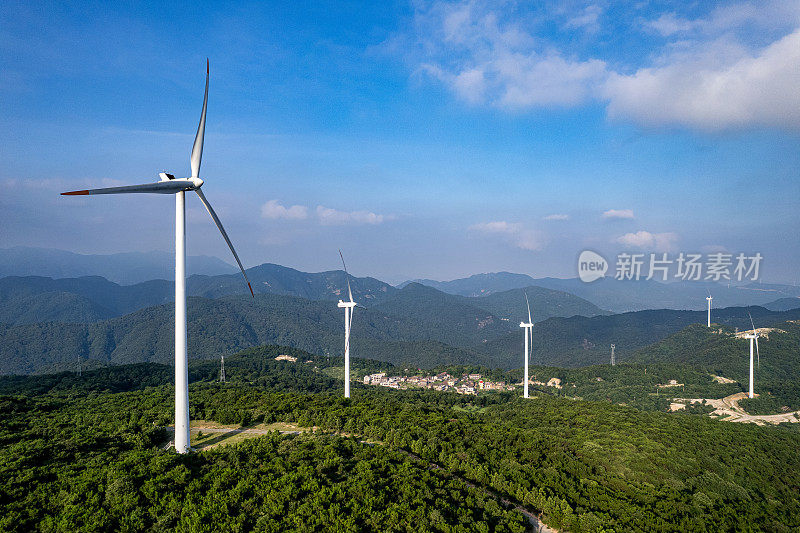 风力涡轮机和阳光山上的村庄