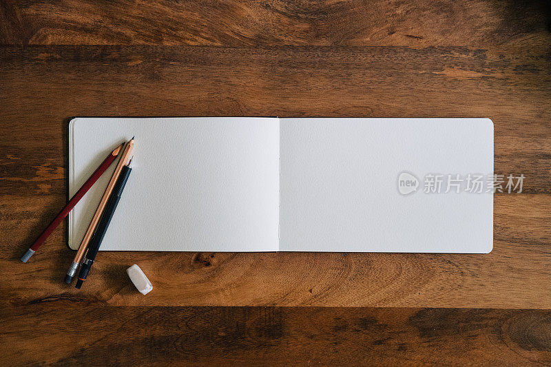 水平风格空白速写本在木桌与蜡笔