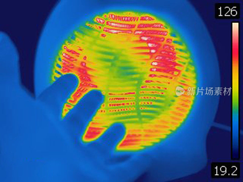 人的手在家用电加热器前的热图像