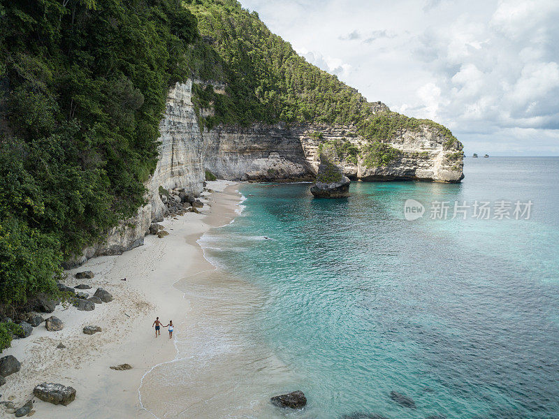 鸟瞰热带海滩上的年轻情侣享受度假和大自然，人们旅游探险的理念