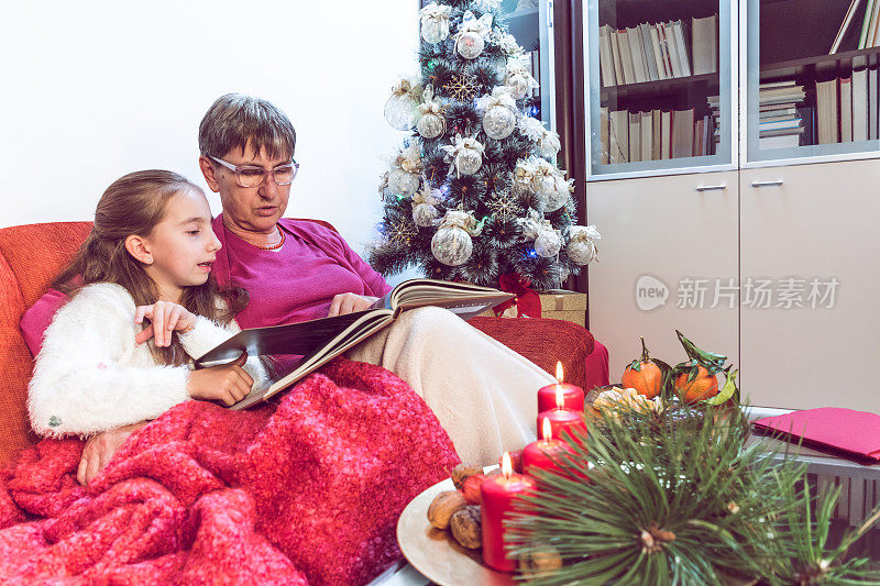 圣诞节期间，奶奶看书，孙女玩得很开心