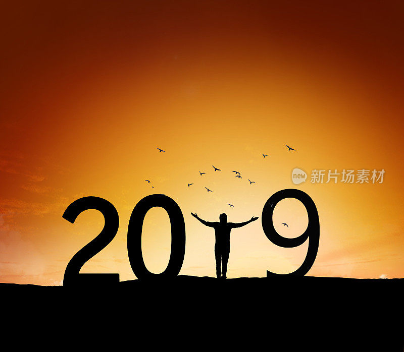 2019年，一个成功男人站在山上举手的剪影