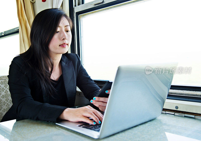 年轻的女商人在上班途中使用笔记本电脑工作