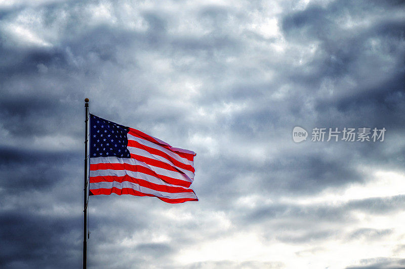 美国国旗在阴暗不祥的天空中飘扬