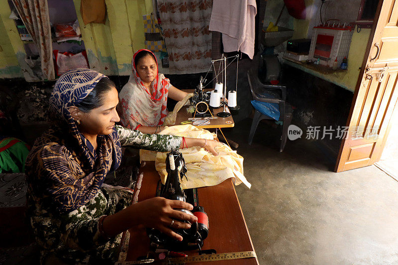 农村妇女用机器缝衣服