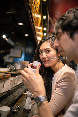 多民族的朋友下班后在户外日本居酒屋酒吧约会