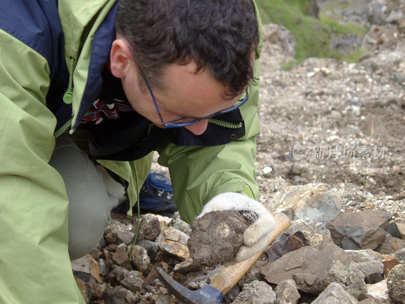 男地质学家科学家男人在采石场看岩石样本