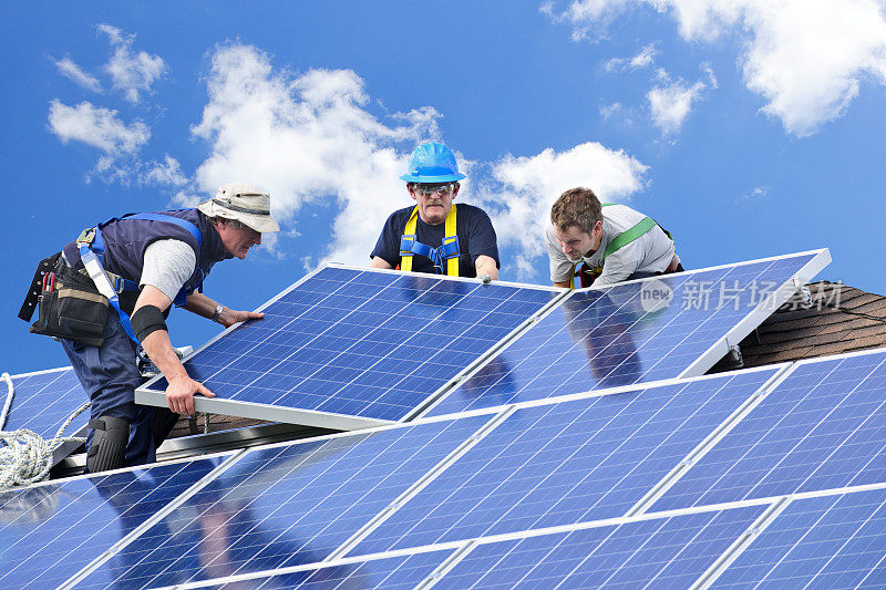 三个男人在屋顶上安装太阳能电池板