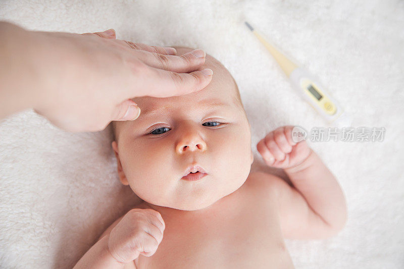 母亲为生病的婴儿检查体温