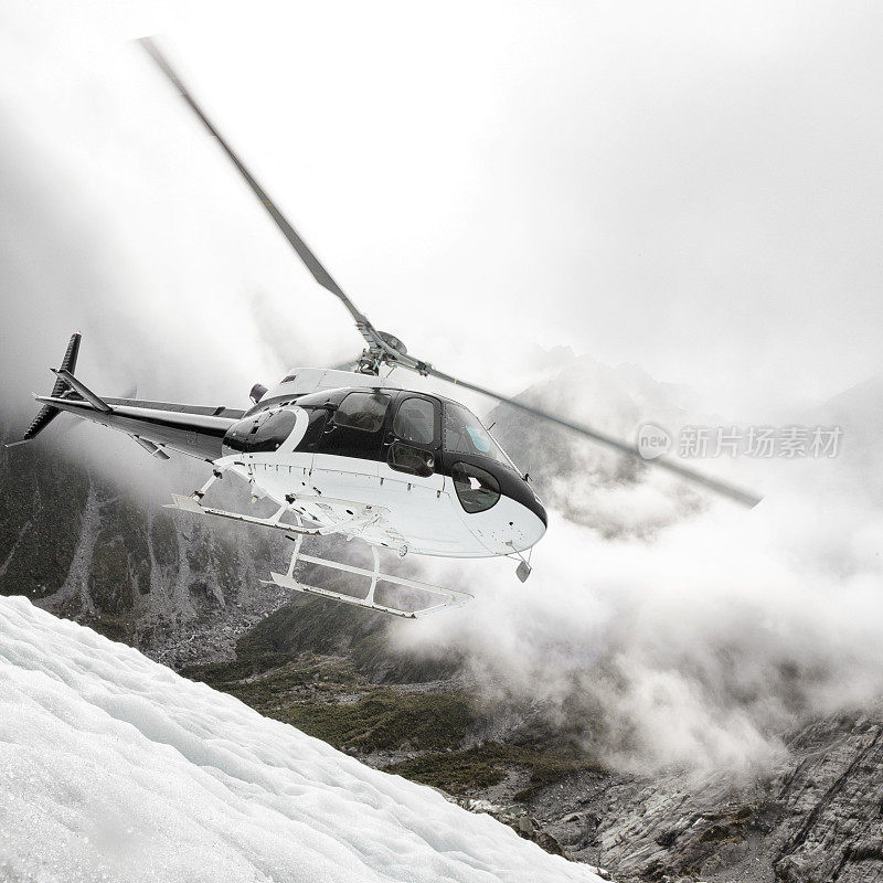 一架直升飞机降落在新西兰南阿尔卑斯山的弗朗茨约瑟夫冰川上
