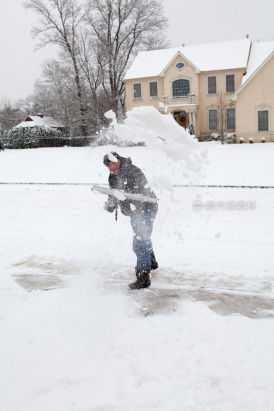 老人在暴风雪后铲雪