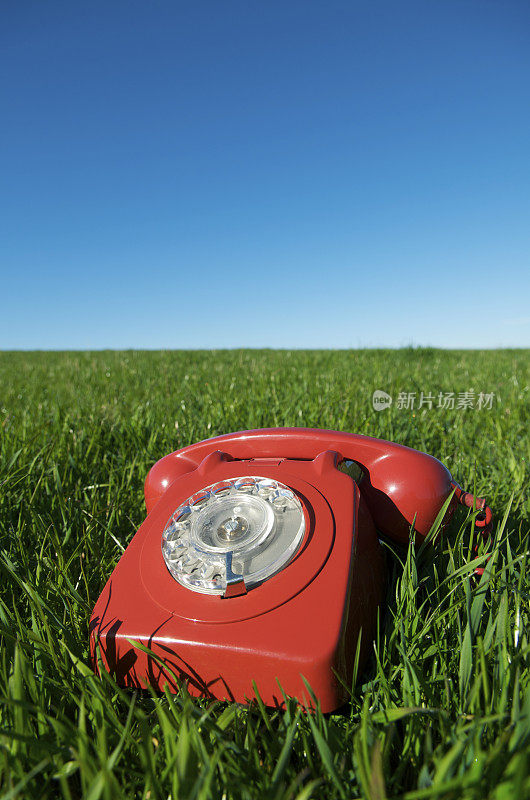 老式的红色电话在草地上