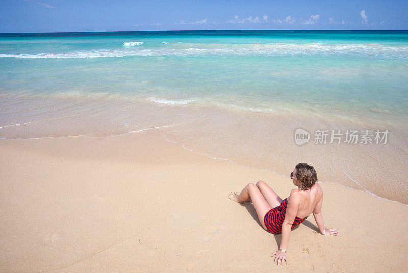 在热带海滩上晒太阳的女人