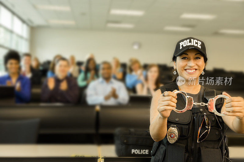 法律:女警察在教室里和警察学员说话。手铐