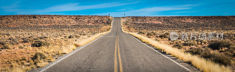 漫长笔直的沙漠道路穿过干燥的景观犹他州纪念碑谷