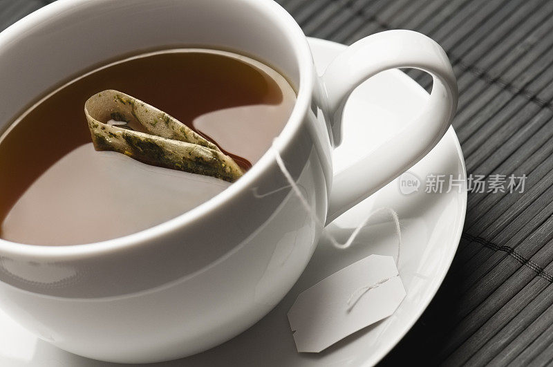 阿萨姆红茶和茶包在白色的茶杯和茶碟里