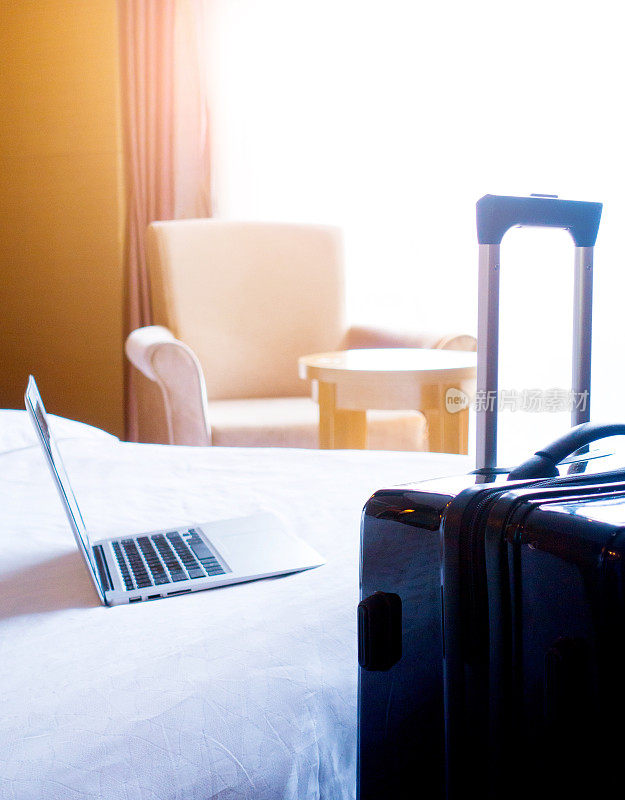 笔记本电脑和手提箱在酒店房间里