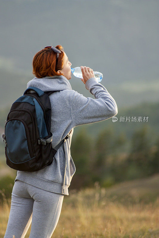 徒步旅行的女人喝瓶子里的水