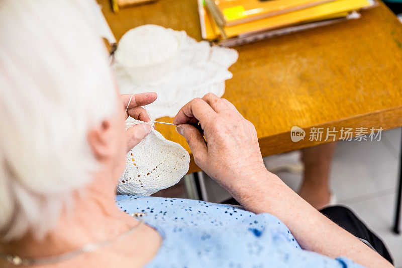 在社区中心从事钩针工作的老年妇女