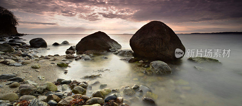 鲁根岛海景与巨大的巨石下戏剧性的多云天空