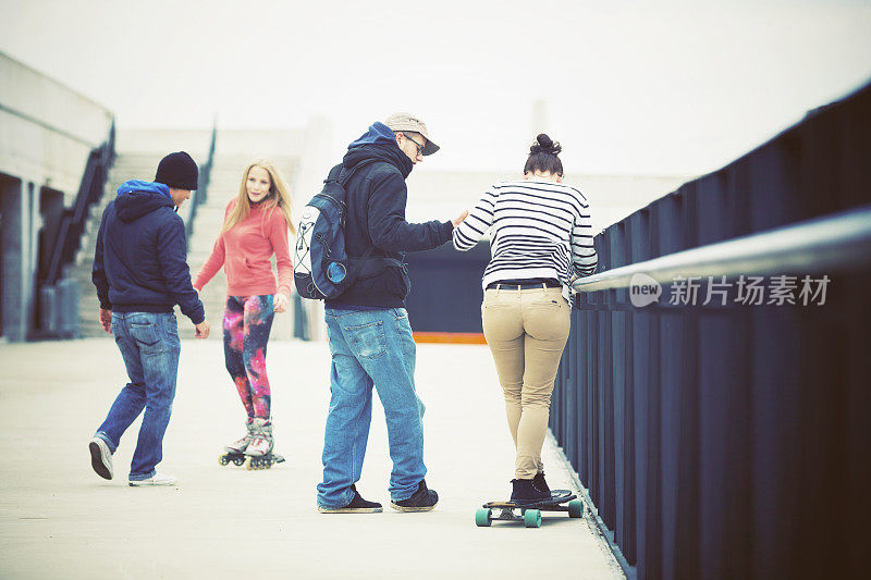 一群青少年在户外玩滑板和溜冰鞋