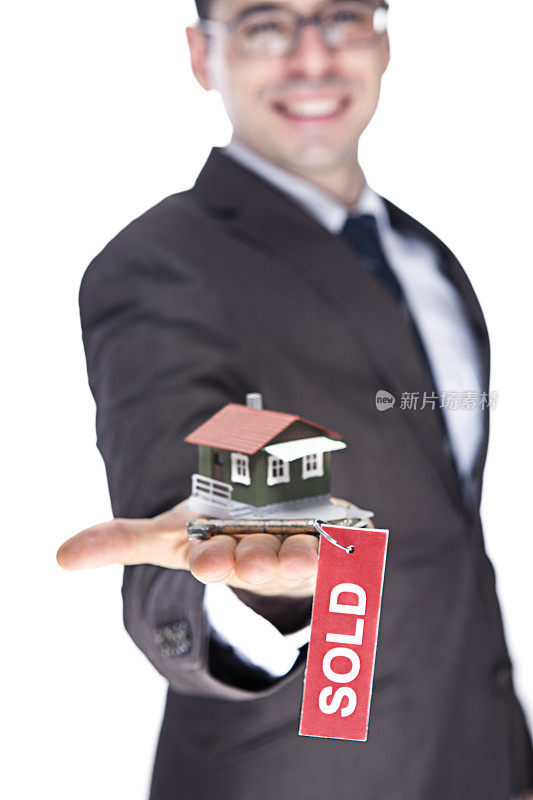 男拿着房子模型，手里拿着钥匙