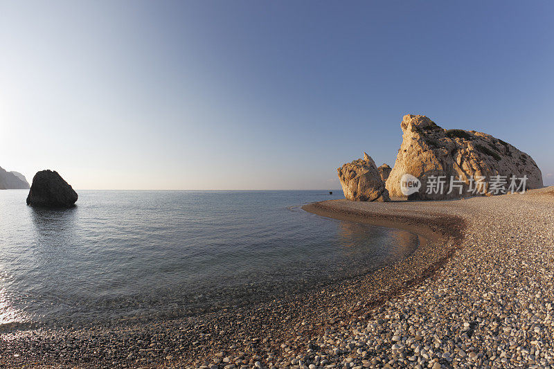清晨的阳光阿芙罗狄特海滩塞浦路斯金色的卵石岩石