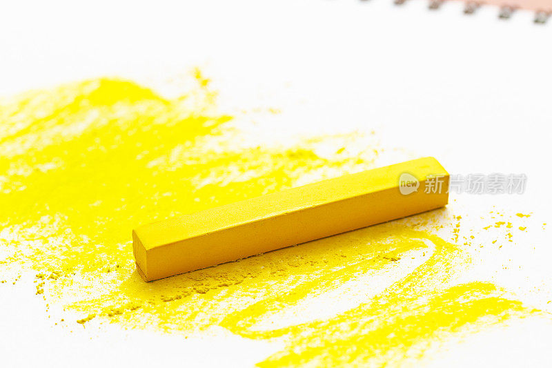 鲜艳的黄色蜡笔给白色画板上色